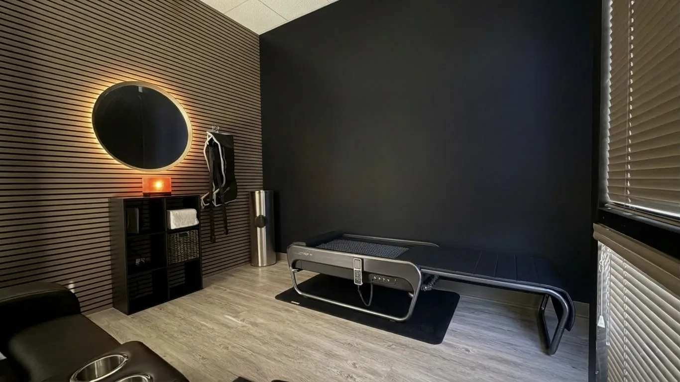 Treatment room with a slatted wood wall and round mirror